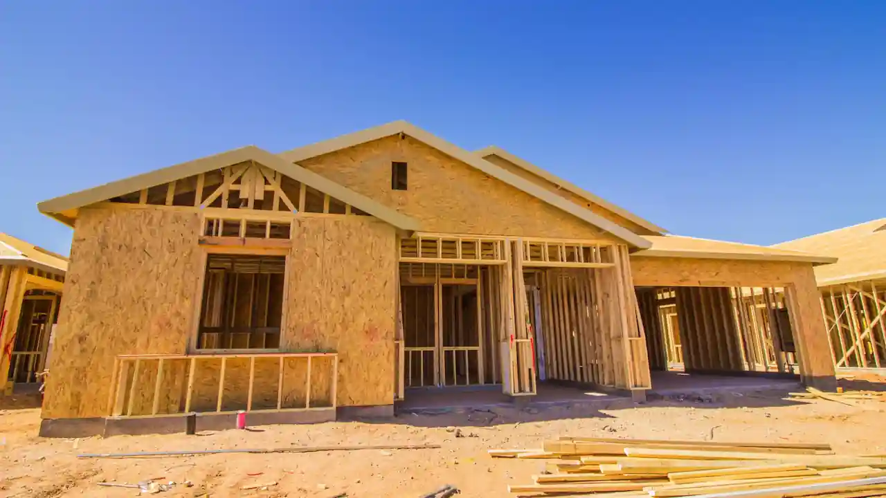 Custom home under construction showing structural framing and unfinished exterior work during residential building.