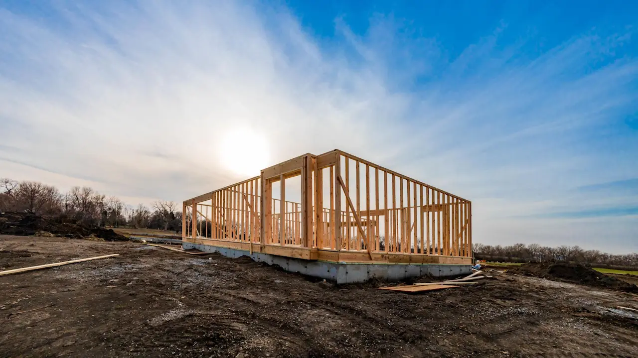 Residential home under construction showing wooden framing and the potential for owner builder savings.