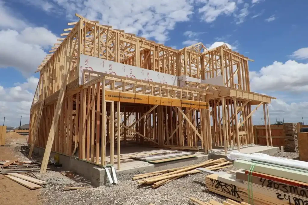 Residential home under construction with exposed wooden framing during an owner-builder project.