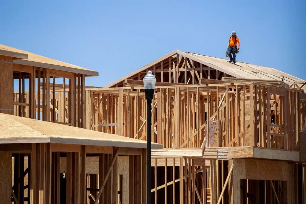 New residential house under construction with wooden framing and structural work in progress.